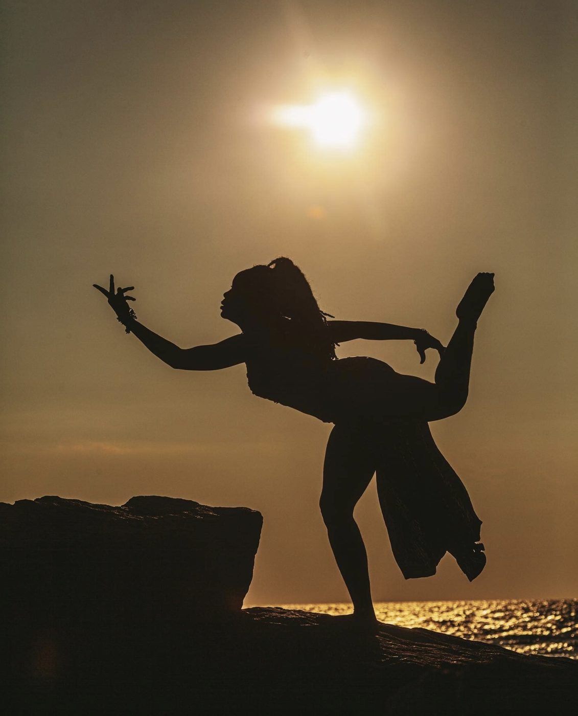 Silhouette of a dancer in arabesque at sunset